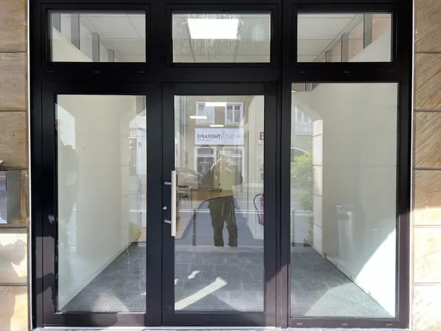 Doppelflügelige Glas-Eingangstür mit Oberlichtern in einem Treppenhaus