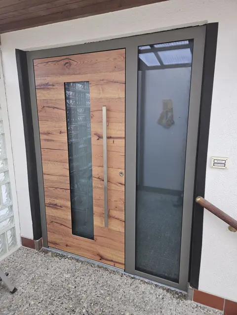 Haustür in Holzoptik mit schmalem Glasstreifen und Seitenteil